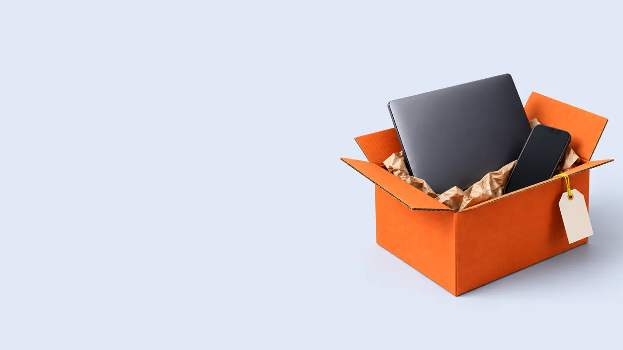Ноутбук и смартфон в открытой оранжевой коробке с пустой биркой на светлом фоне, обложка статьи о технологическом сборе